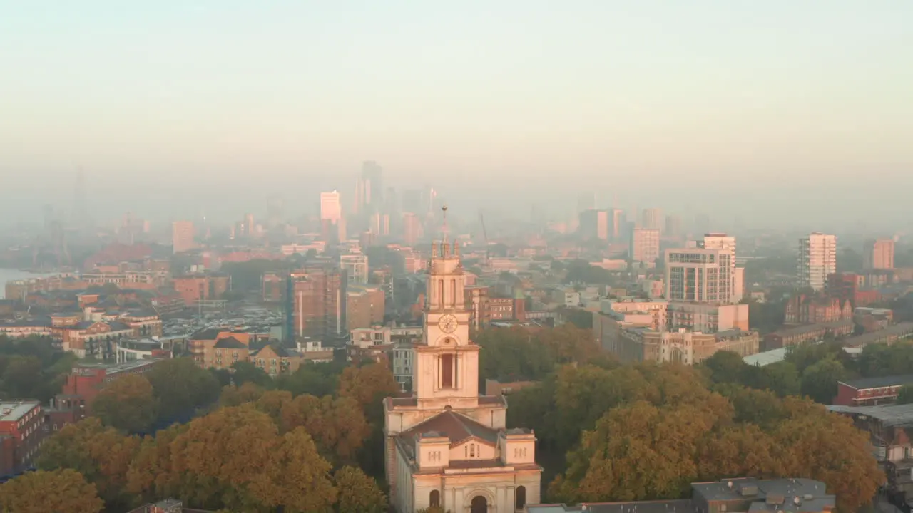 Close up aerial shot of St Annes Church Limehouse at sunrise with central London skyline in the background