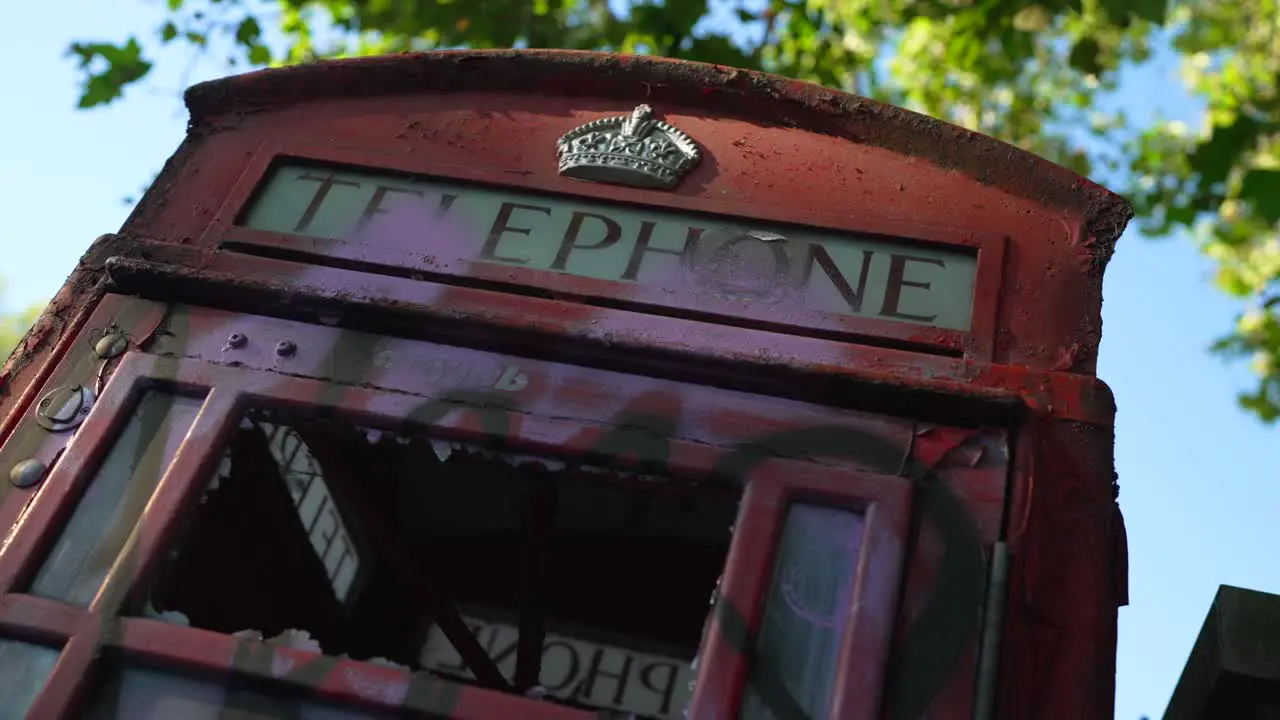 Red telephone booth vandalized after the riots in the city of london