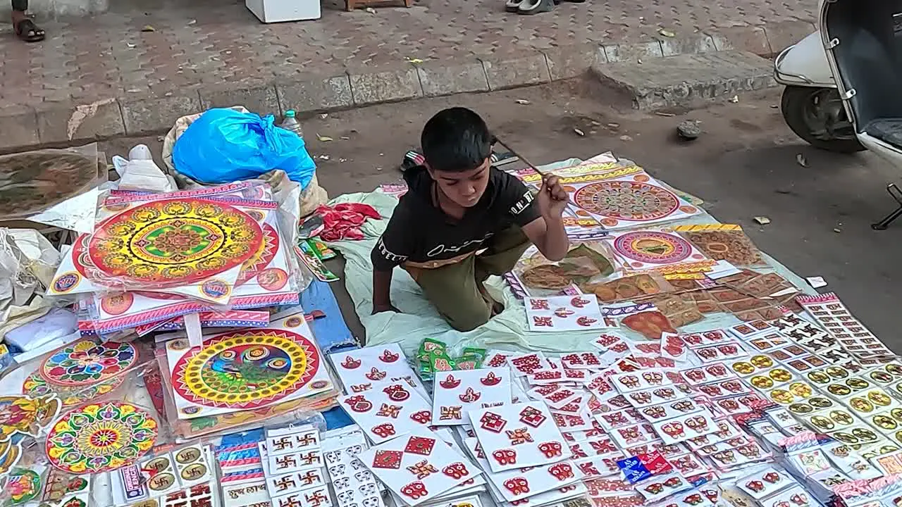 A young boy is selling decorative items on the street road to earn his livelihood