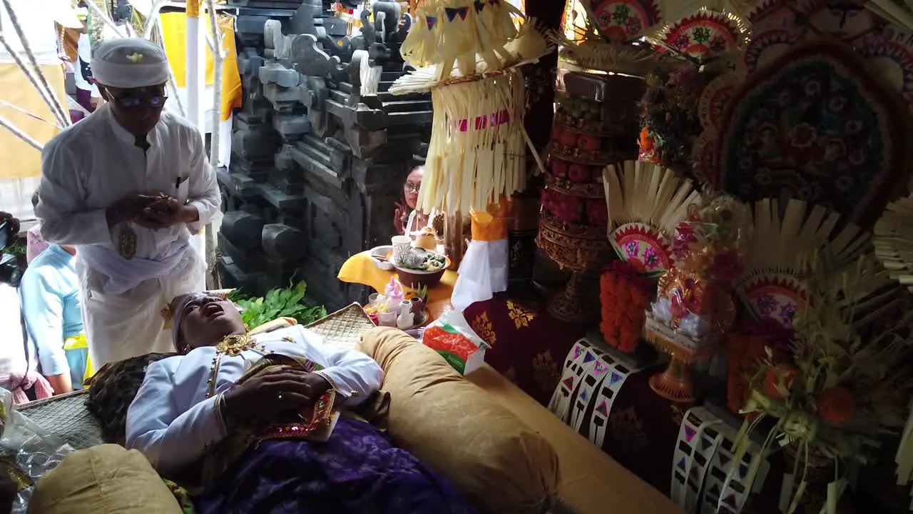 Balinese Hindu Priest Performs Tooth Filing Ceremony at Colorful Temple of Bali Indonesia Ornaments Ancient Tradition for Trespassing Youth into Adulthood