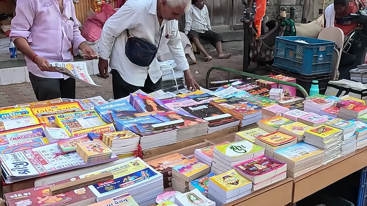 A shopkeeper on Street Road is selling local language books and calendars