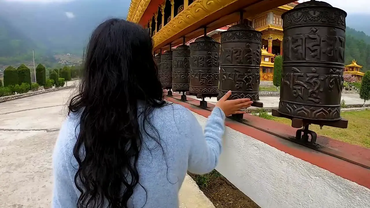 girl spinning Buddhism religious holy wheels at monastery from flat angle video is taken at dirang monastery arunachal pradesh india