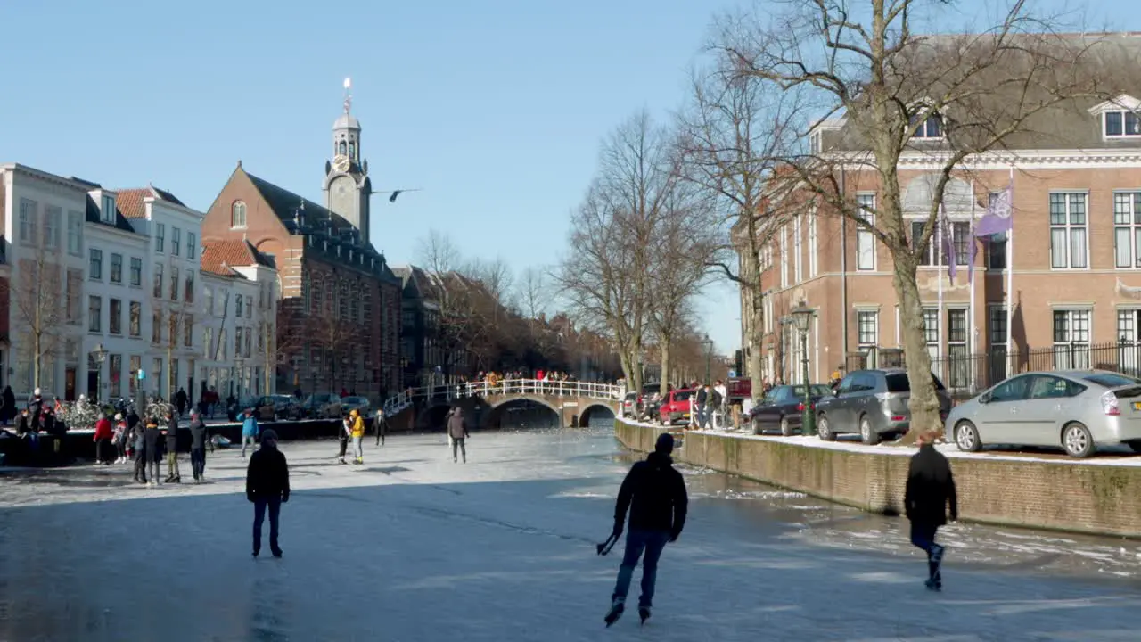 People ice skating on the famous Rapenburg canal in front of the Academy Building in Leiden the Netherlands during the pandemic