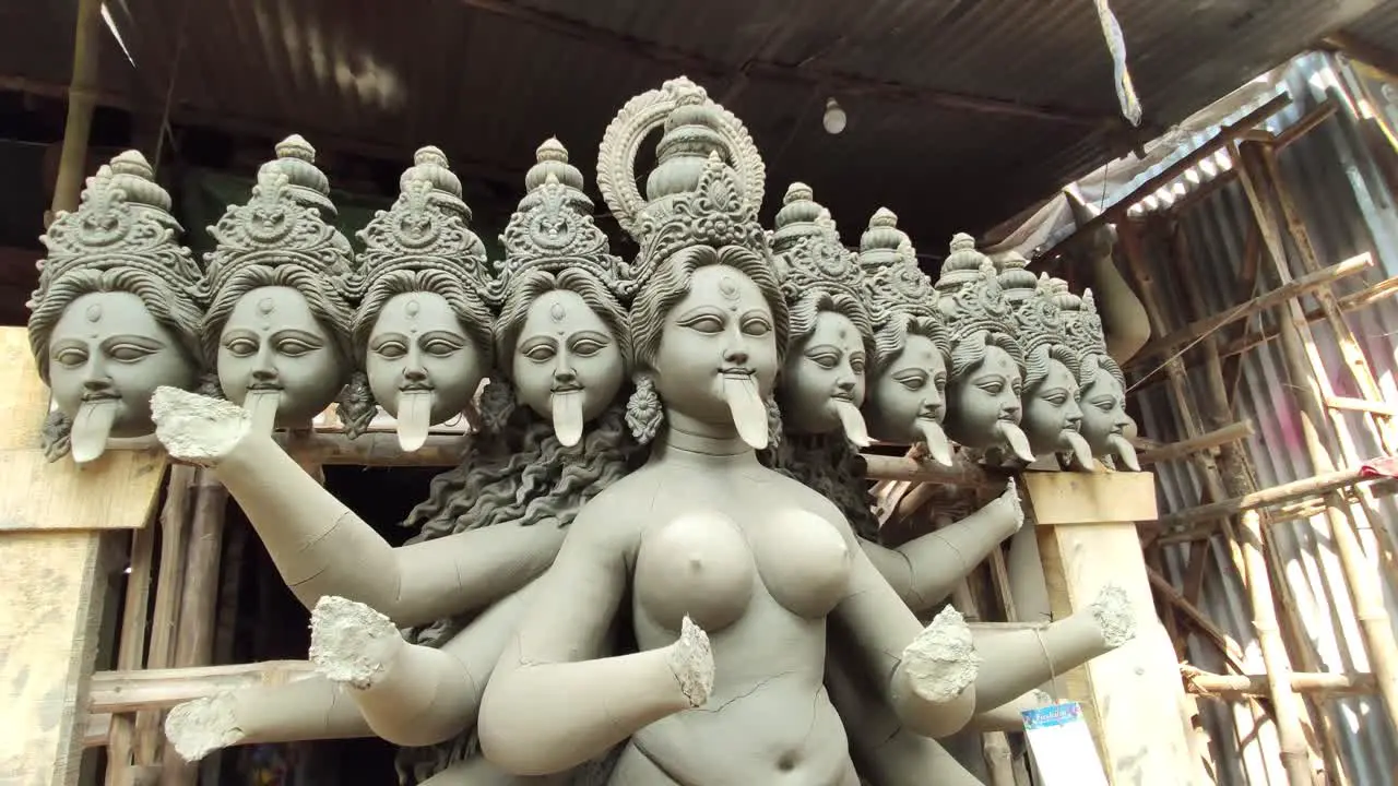 Slow camera movement around unfinished clay idol of Indian Goddess Kali