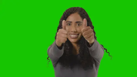 Studio Portrait Shot Of Woman Giving Double Thumbs Up Sign Against Green Screen 2