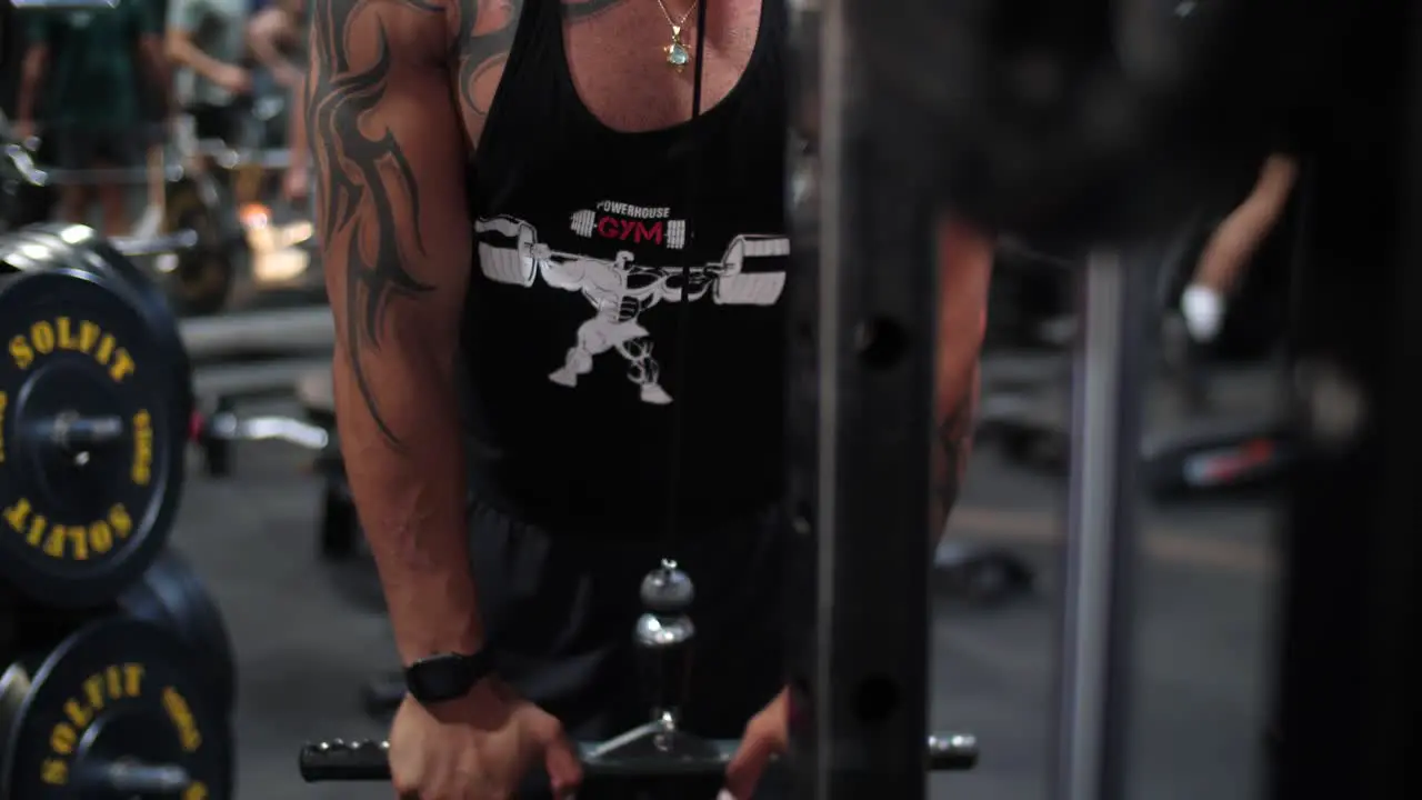 A muscular male bodybuilder lifting weights at the gym