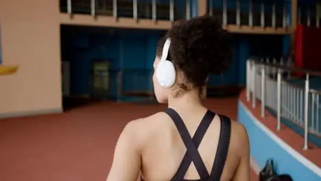 Afroamerican woman with headphones at the gym