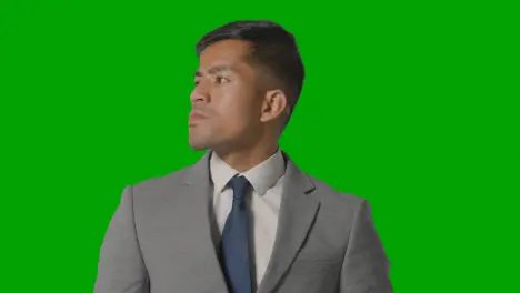 Portrait Of Serious Businessman In Suit Against Green Screen Looking At Camera 1