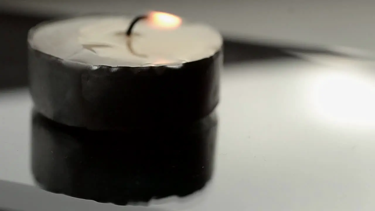 Candle and flame reflecting in glass