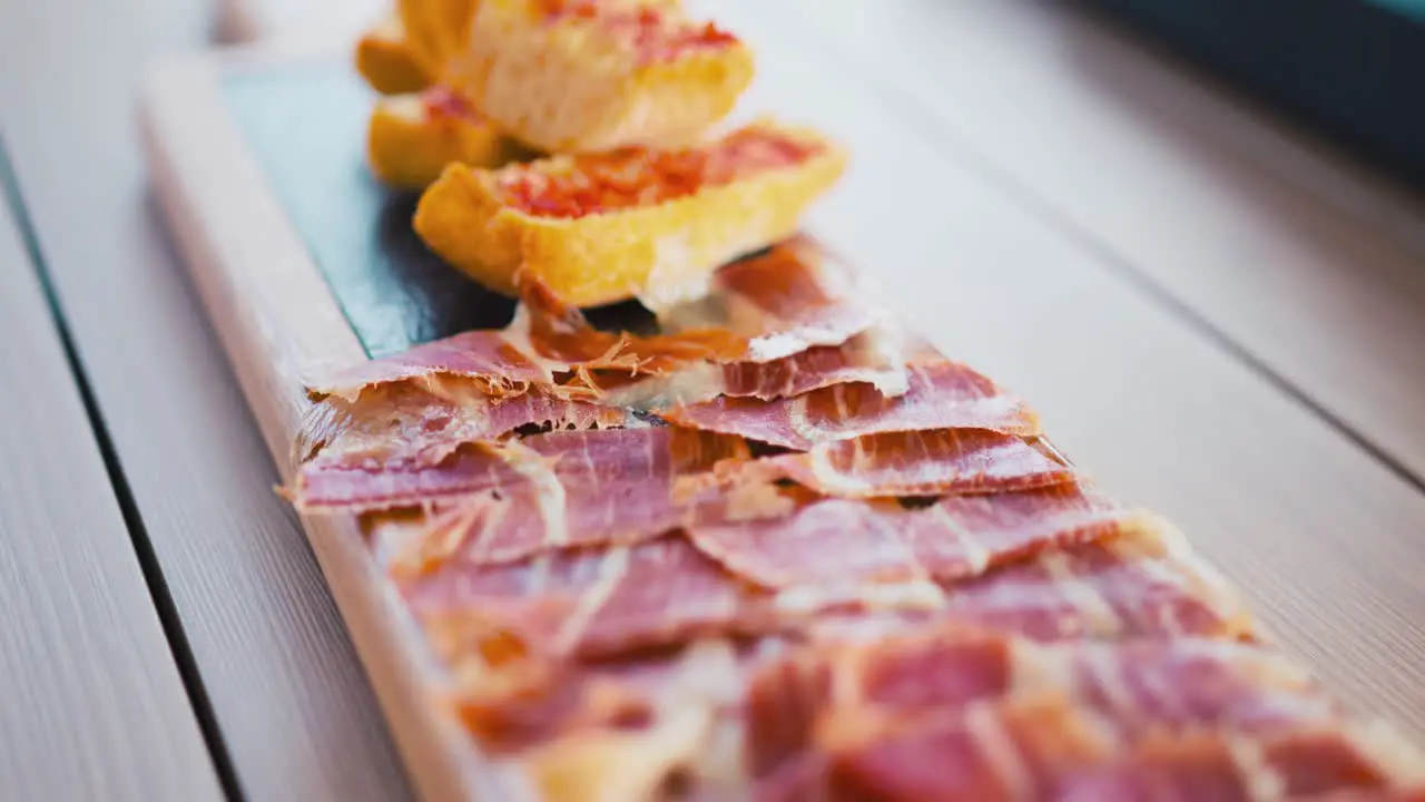 Platter of Iberian ham and tomato bread in a showcooking