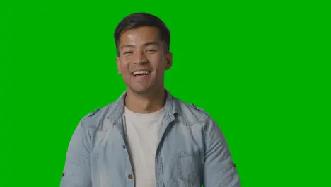 Portrait Of Casually Dressed Smiling Young Man Against Green Screen 1