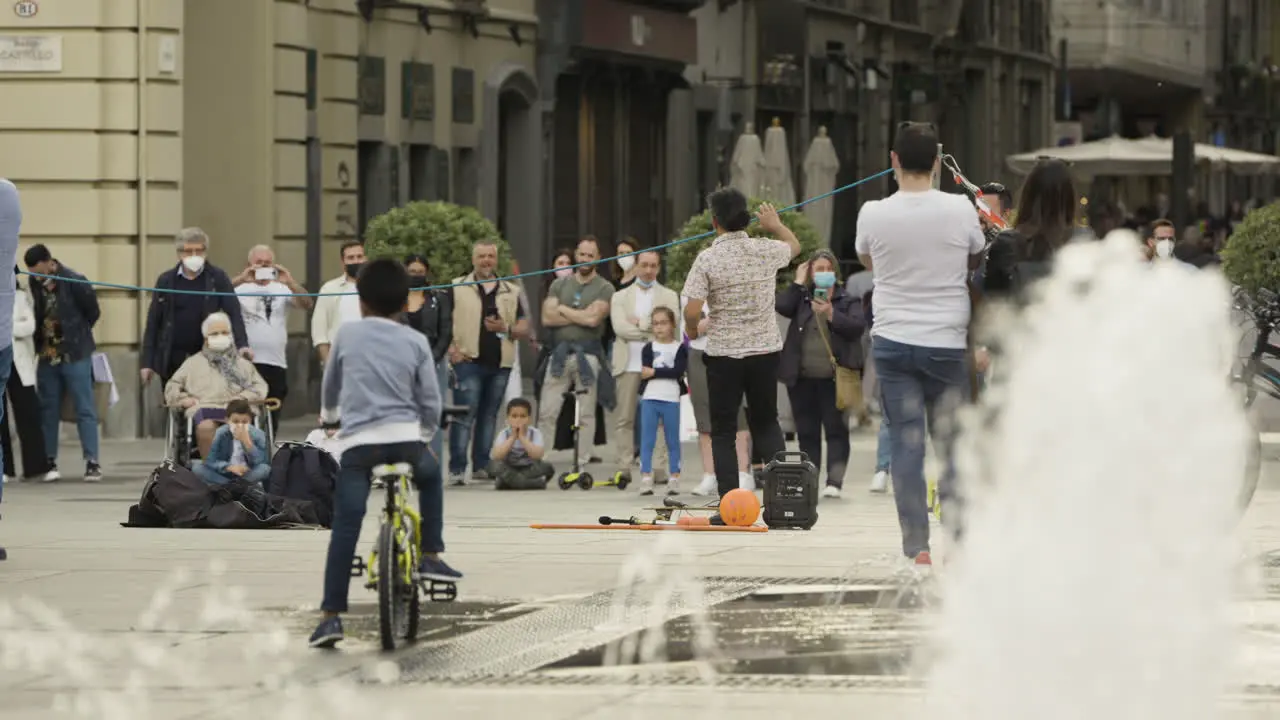 Wide shot of a street performer entertaining crowd