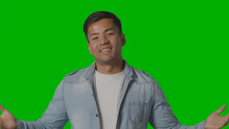 Portrait Of Casually Dressed Smiling Young Man Against Green Screen 