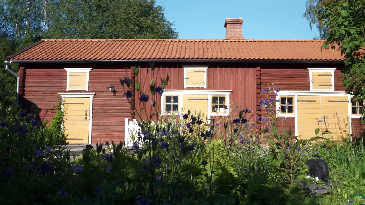 Idyllic Scandinavian Home Red Wooden House With Flowers In Garden