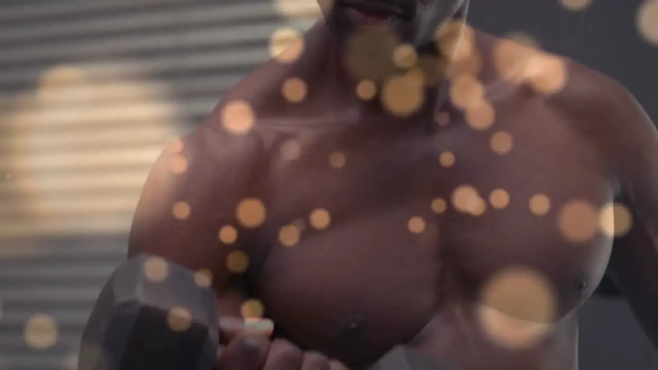 Spots of light against african american fit man working out with dumbbells against red background