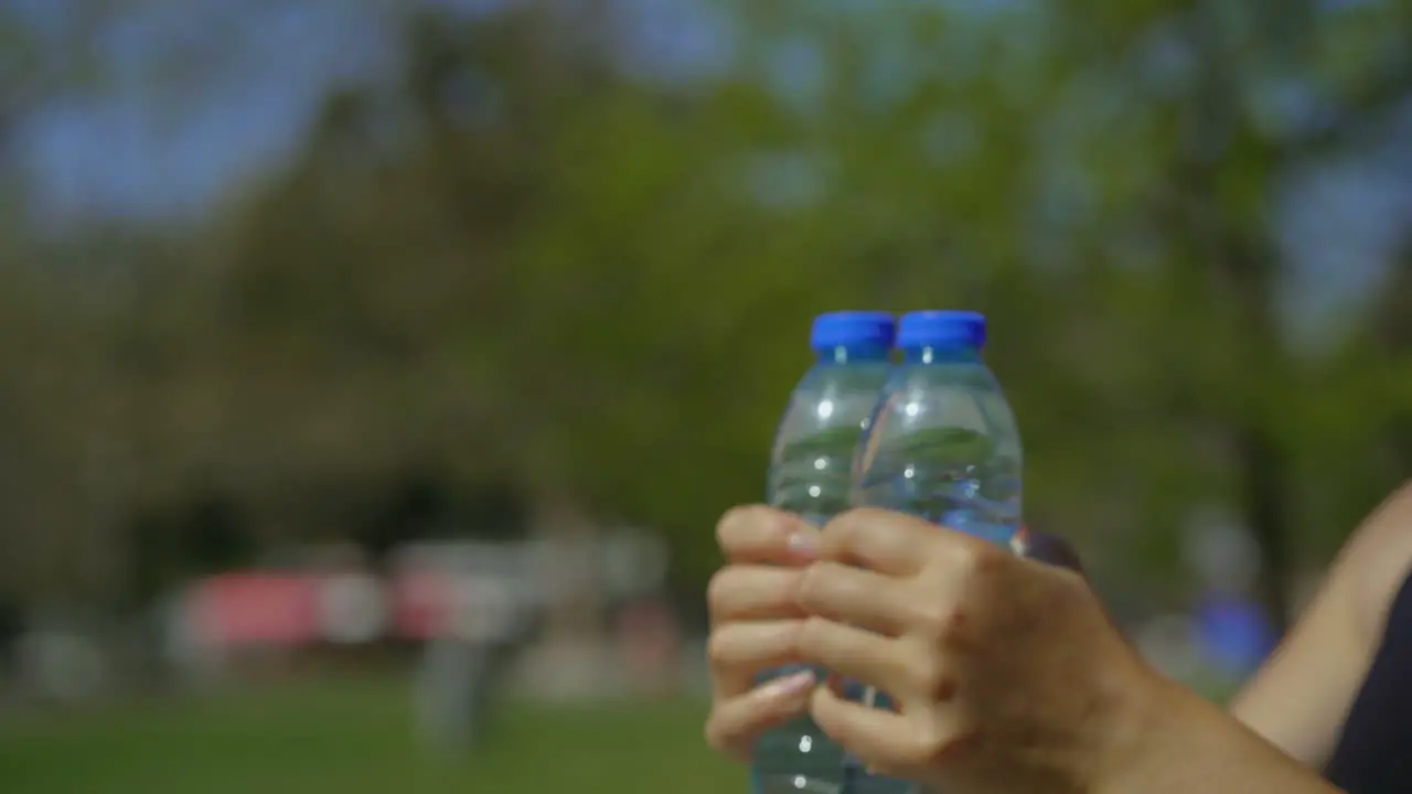 Female hands training with bottles of water