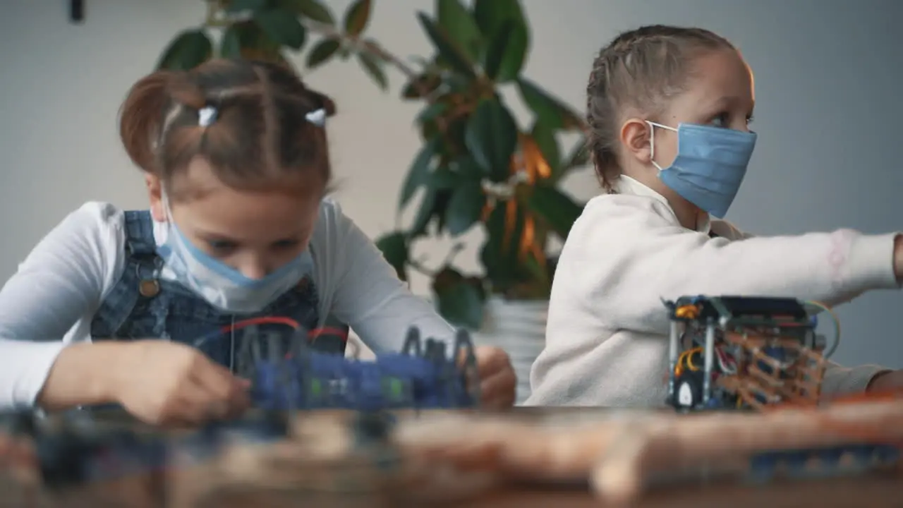 Little Girls With Face Mask Building Robots 1