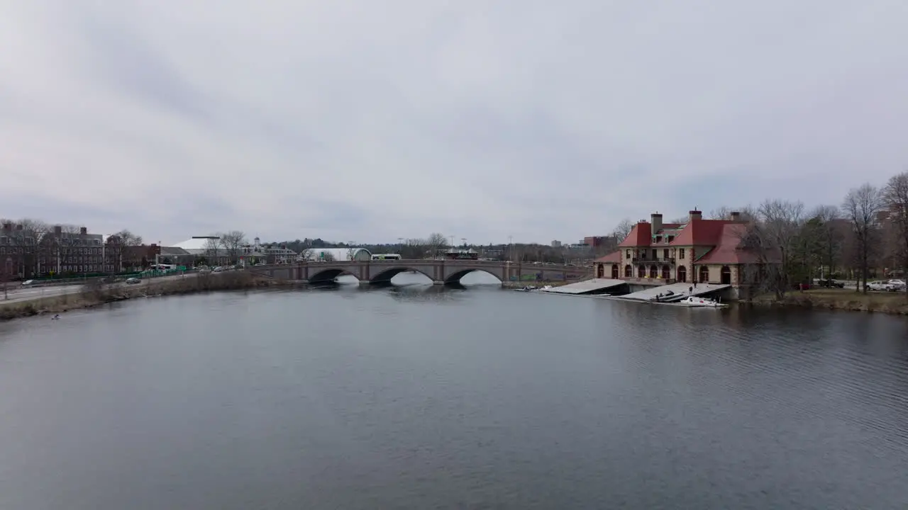 Winter or early spring landscape in city Forwards fly above Charles river at Weld Boat House Vehicles driving on Anderson Memorial Bridge Boston USA