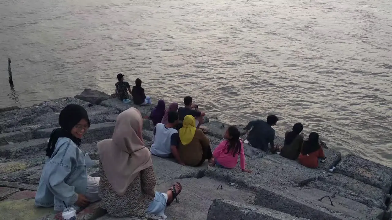 people enjoying the dramatic twilight sky over the beach