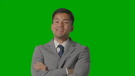 Portrait Of Businessman In Suit Against Green Screen Smiling At Camera