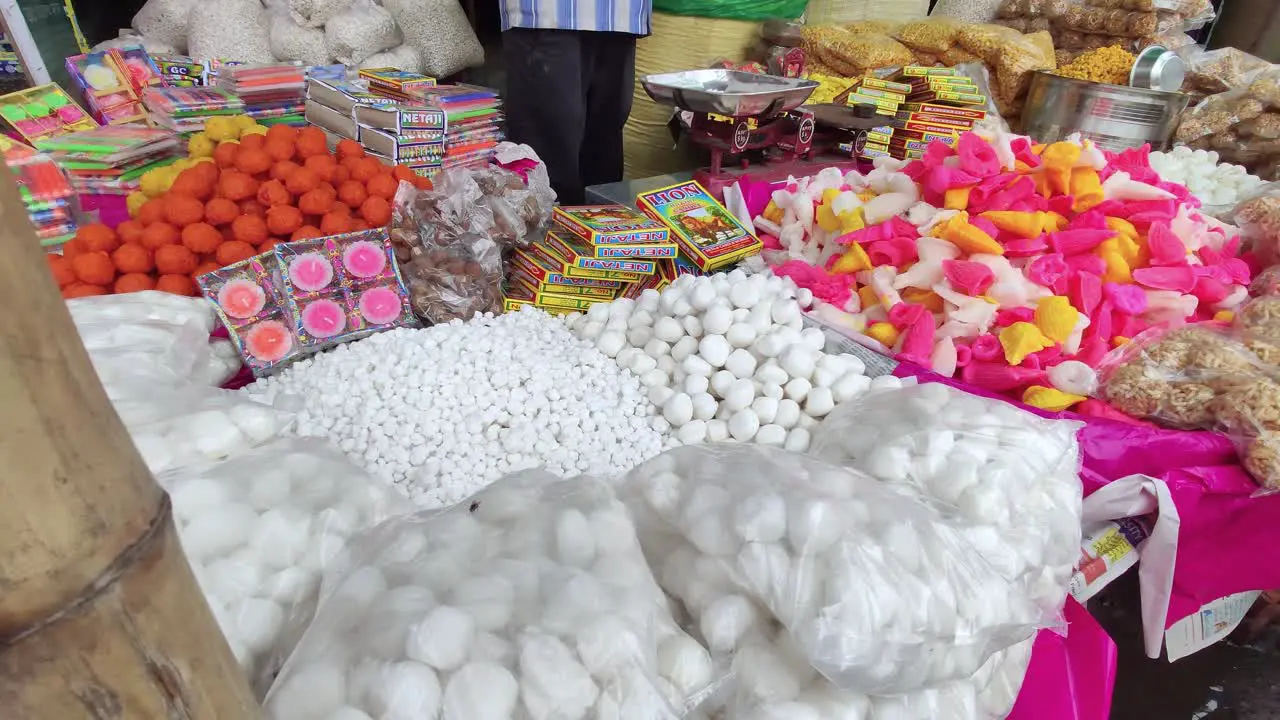 Indian street vendor selling many Diwali festival sweets at market slow camera dolly shot