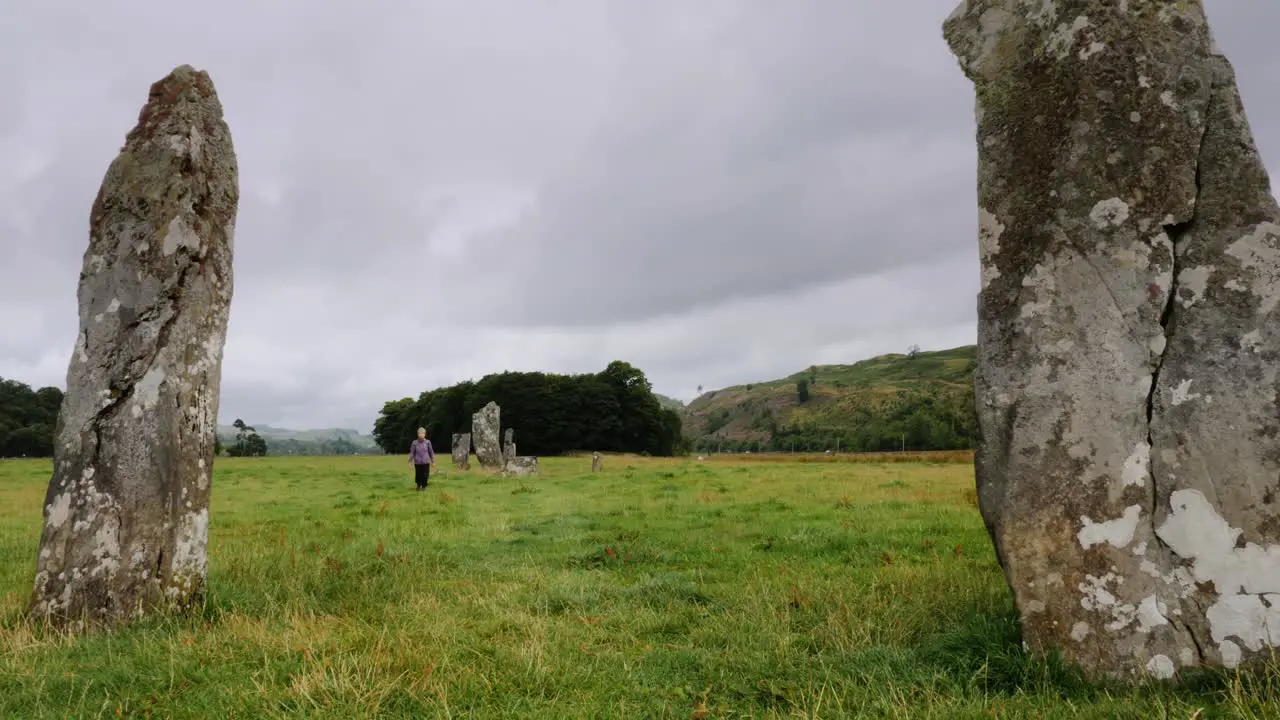 Lady walks through standing stones in Kilmartin Glen