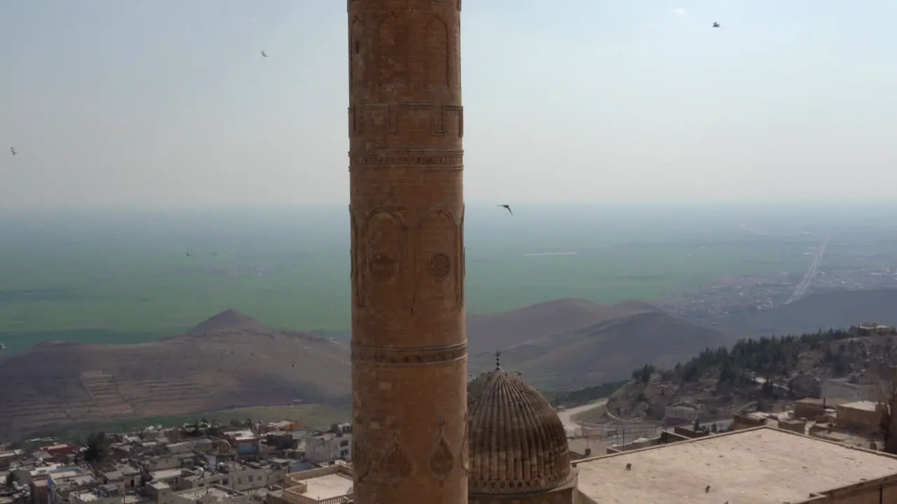 The camera tilts the historical minaret of Mardin Ulu Mosque made of cut stone from top to bottom