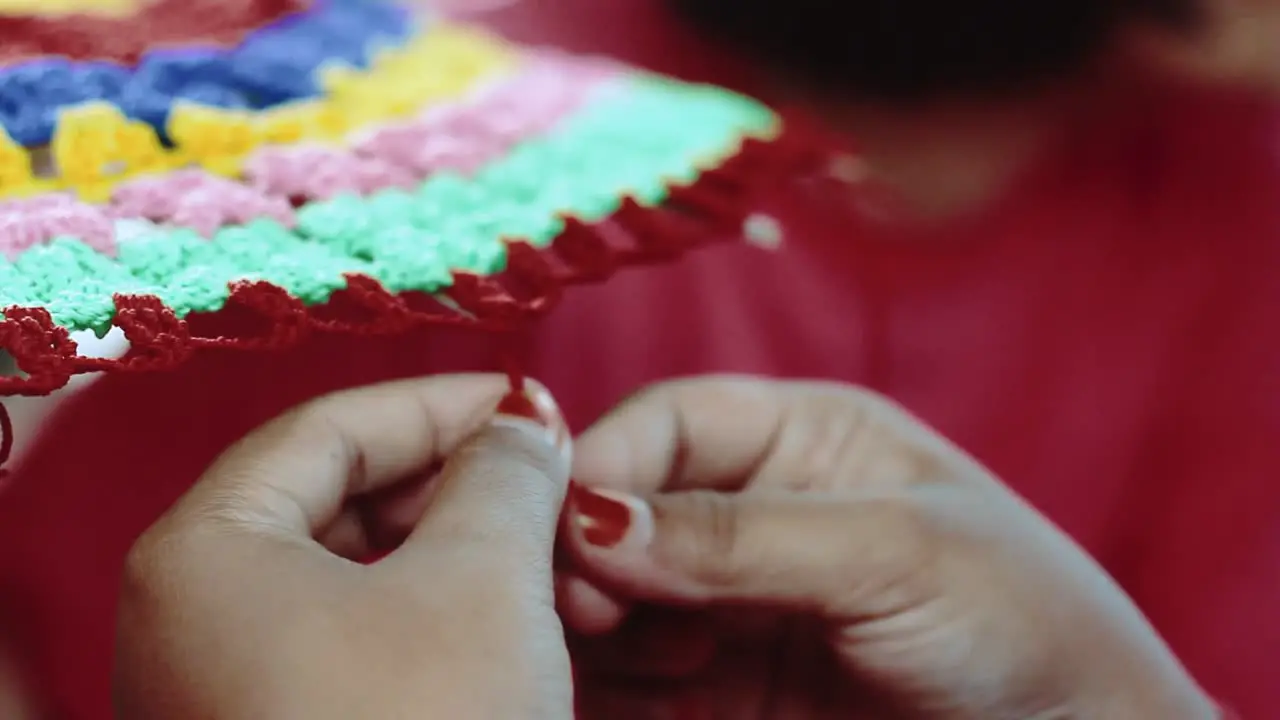 Close up of the hands of an Indian girl knitting the ornaments of a traditional umbrella in India traditional clothing concept