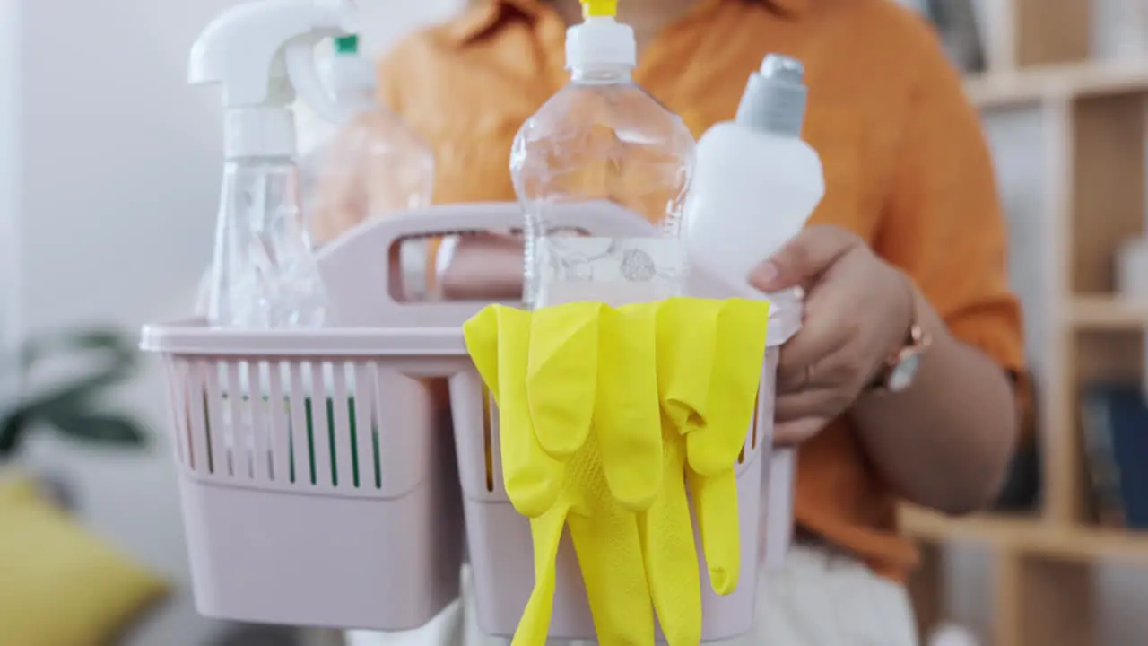 Cleaning supplies basket and woman hands