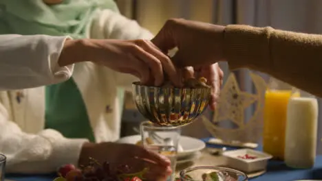 Woman Wearing Hijab At Muslim Family Table At Home Eating Iftar Meal Breaking Daily Fast During Ramadan