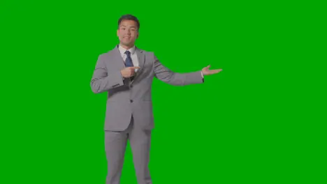 Three Quarter Length Shot Of Businessman In Suit Presenting Or Showing Against Green Screen 2