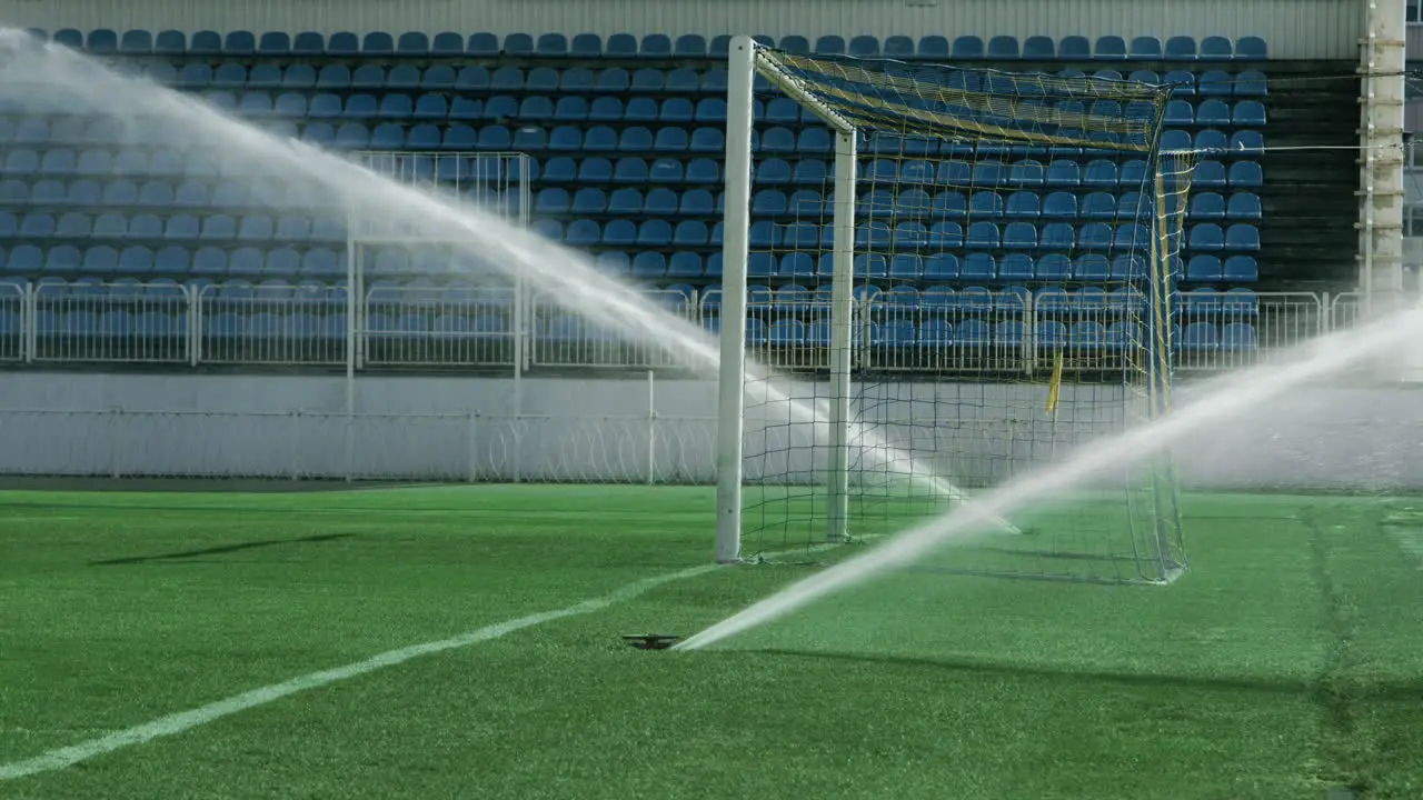 Grass sprinkler on football field Soccer arena water irrigation Watering grass