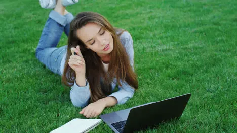 Young woman using laptop computer for freelance work in park