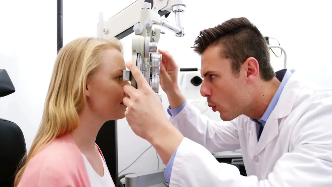 Optometrist examining female patient on phoropter