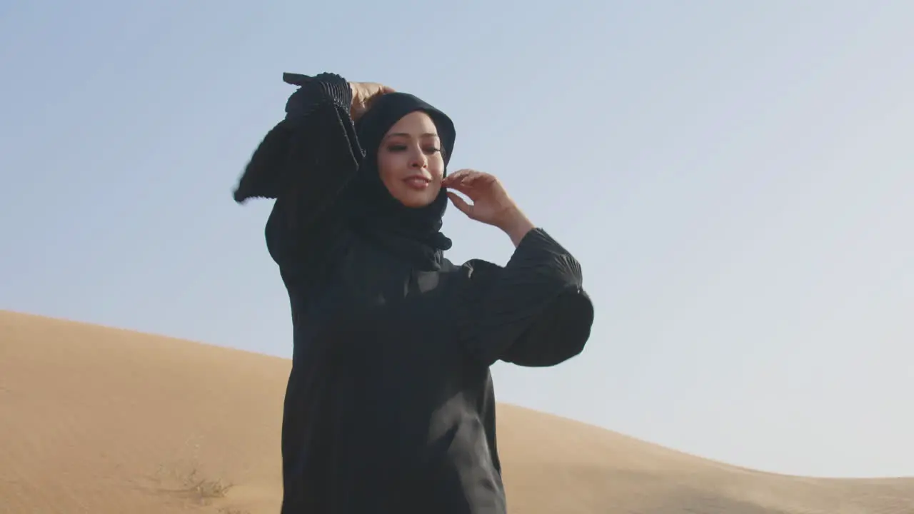 Hermosa Mujer Musulmana Con Vestido Negro Tradicional Y Hiyab Posando En Un Desierto Ventoso