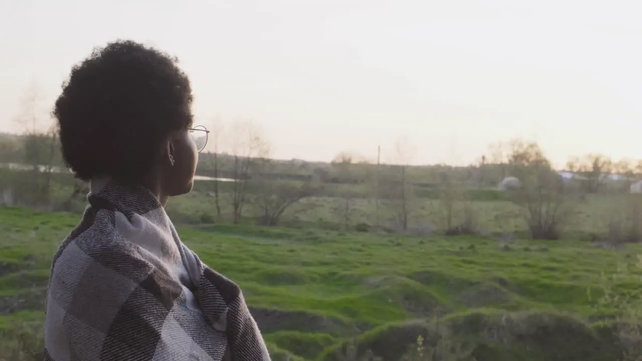 Una Mujer Joven Contemplando La Puesta De Sol En El Bosque Cubierta Por Una Manta 1