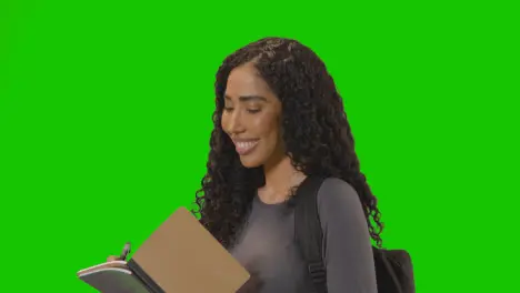 Portrait Of Female College Or University Student Against Green Screen Smiling At Camera