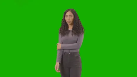 Three Quarter Length Portrait Of Sad Looking Woman Against Green Screen