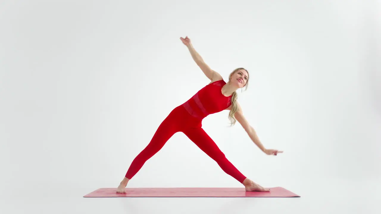 Millennial-Frau Die Sich In Yoga-Pose-Meditation Dehnt Isoliert Auf Weißem Hintergrund In Roter Sportbekleidung Porträt Einer Jungen Yoga-Praktizierenden Die Für Den Kopierraum Posiert 4k