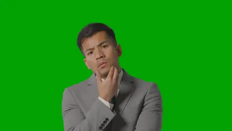 Portrait Of Serious Businessman In Suit Thinking Against Green Screen Looking At Camera 1