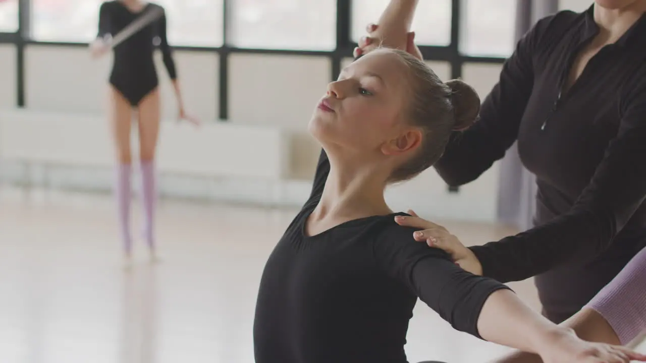 Profesora Corrige La Posición Del Brazo Y La Cabeza De La Chica Gimnástica En La Clase De Ballet