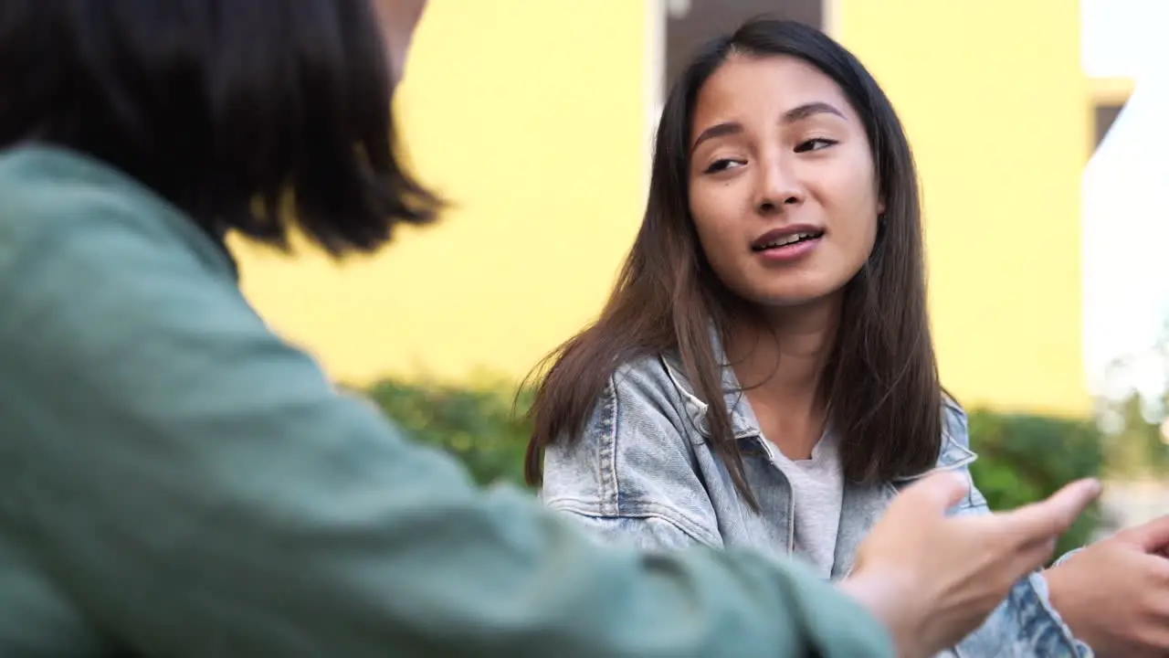 Dos Chicas Japonesas Muy Jóvenes Sentadas Y Hablando Juntas Al Aire Libre 2