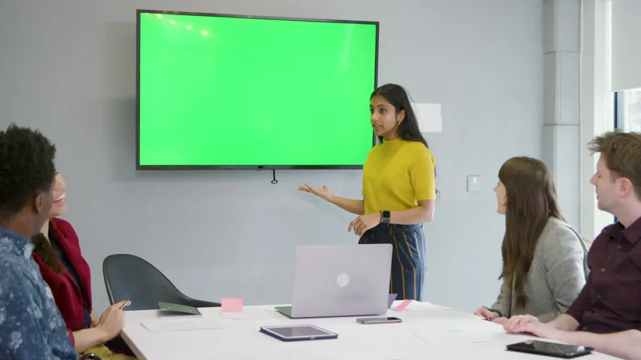 Woman Presenting To Business Colleagues Using Green Screen