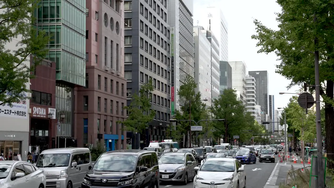 Traffic jam along Midosuji street with big city buildings and road full of cars in osaka cityscape view