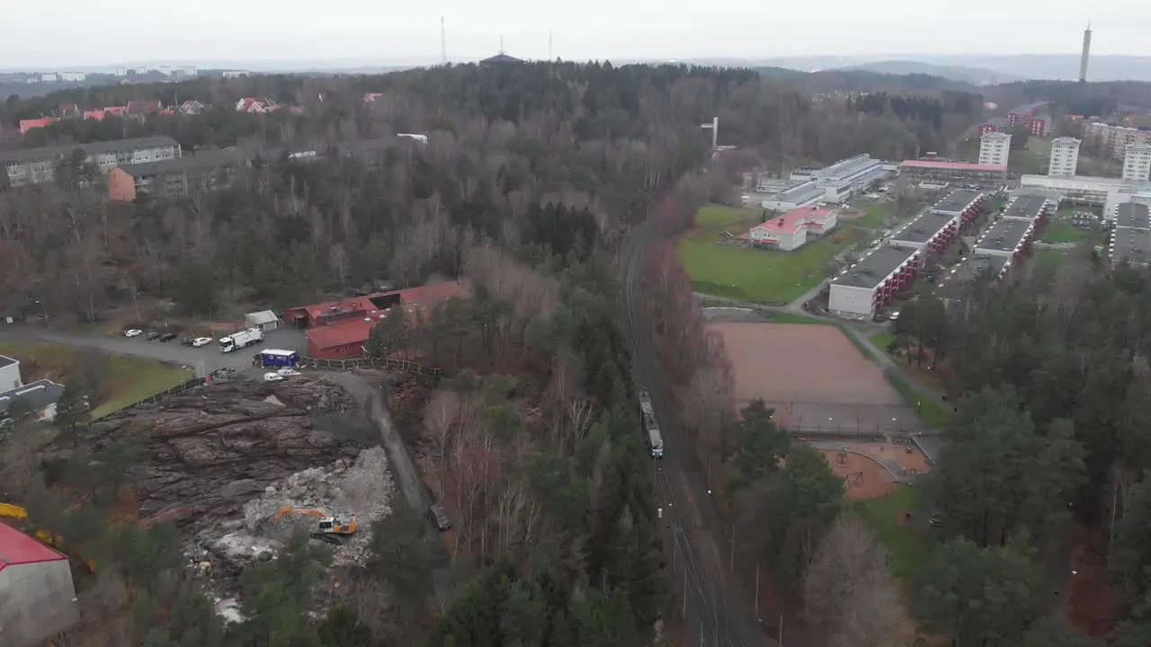 Wide aerial view of a tram traveling cross-country in suburban Gothenburg Sweden