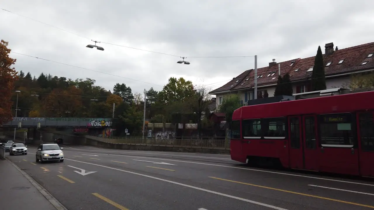 A Red Tram Train Wagon Rides the Streets of Bumpliz Bern Switzerland in Autumn