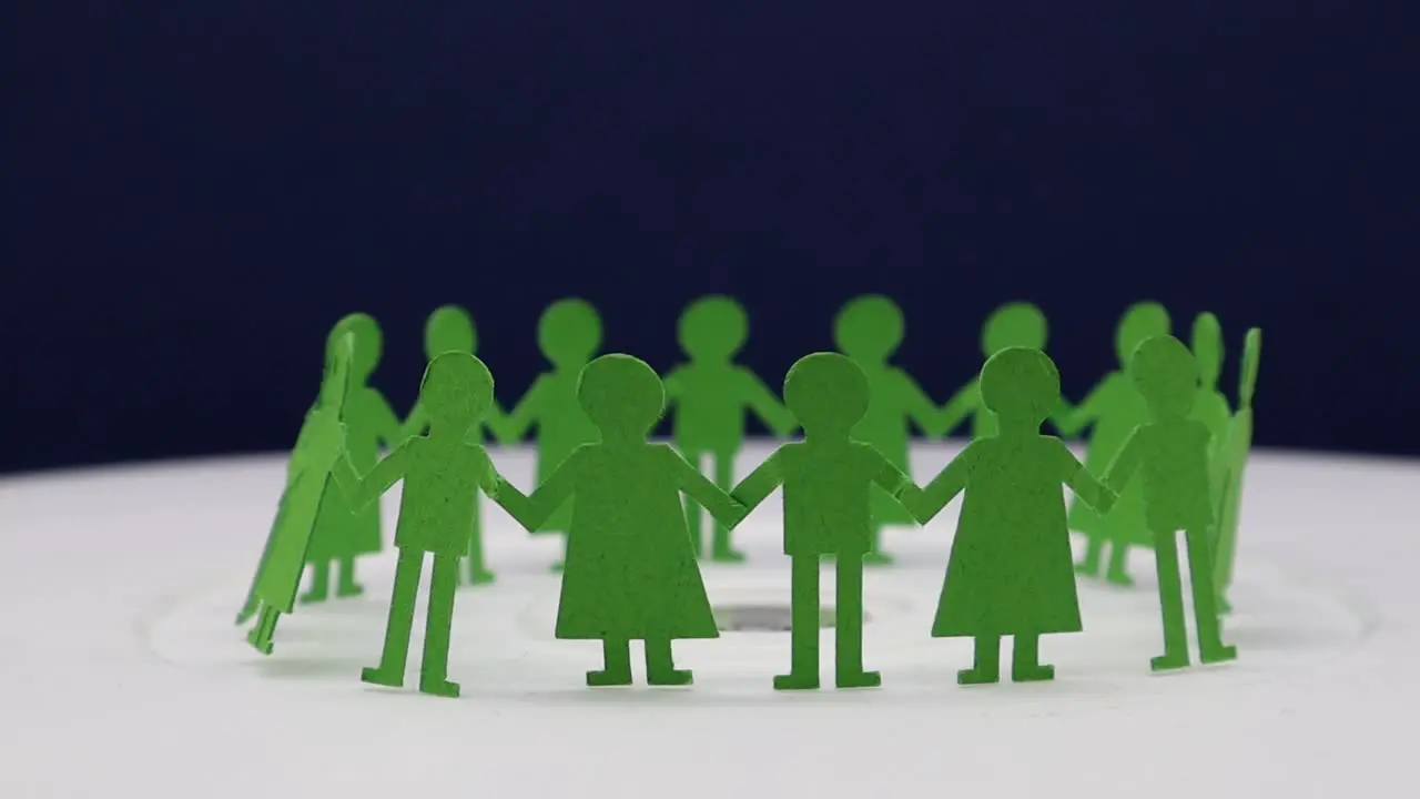 Paper cut of children holding to each other for making a circular dance