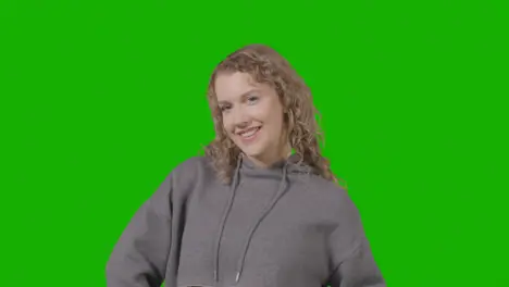 Studio Portrait Of Smiling Young Woman Against Green Screen 1