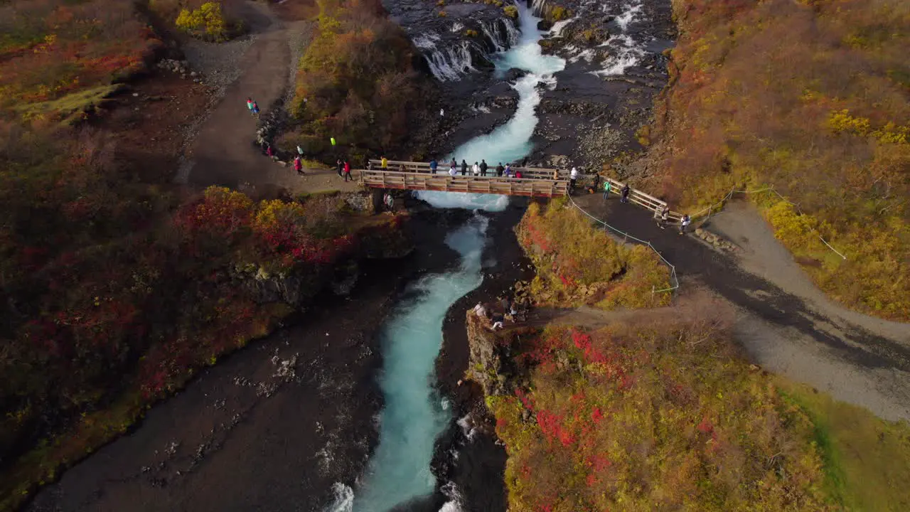 Tourists taking pictures from Brúarfoss waterfall in Iceland