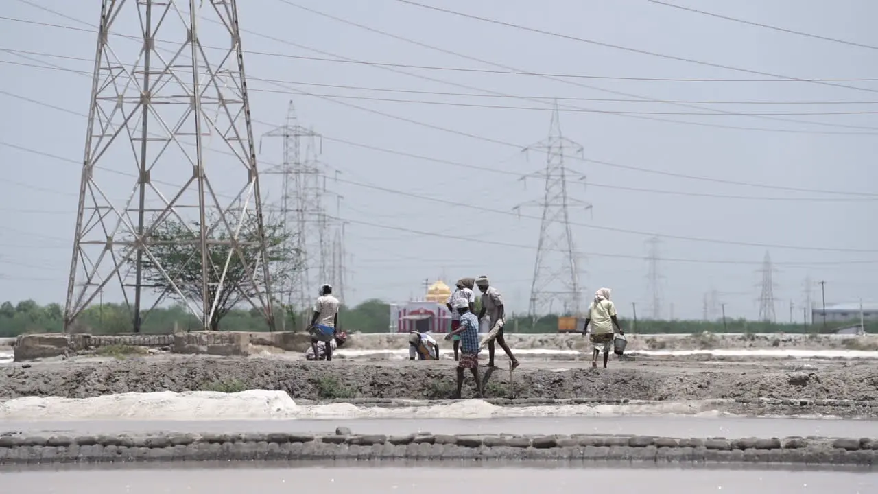 Under the blazing heat of the midday sun people work hard in the salt pan